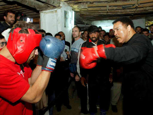 US boxing legend Muhammad Ali (R) practices with the Afghan boxer Gafour as he visits the public health boxing club in Kabul in this November 18, 2002 file photo. Photo/REUTERS