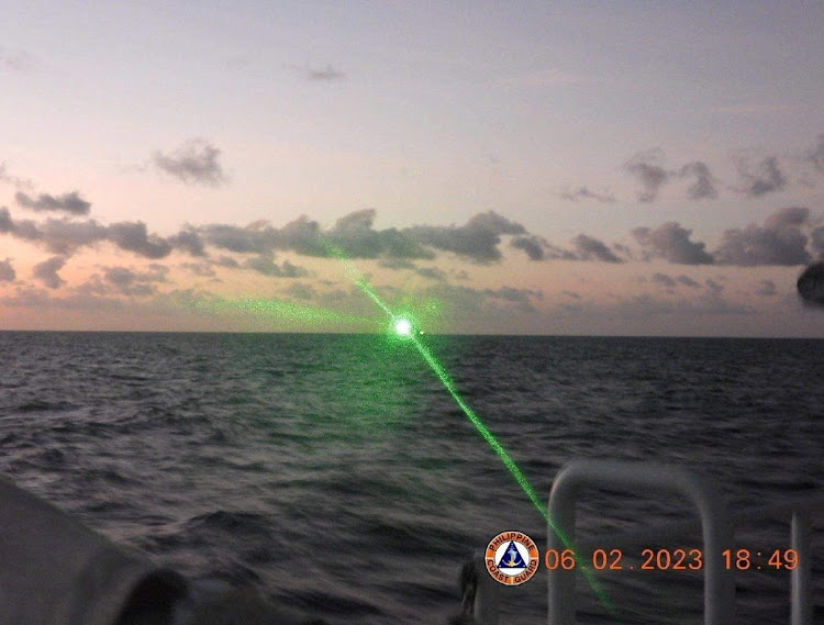 A green light appears from the direction of a Chinese coast guard ship at the Second Thomas Shoal, 105 nautical miles off the Palawan Province, Philippines on February 6 2023 in this handout image. Picture: Philippine Coast Guard via REUTERS