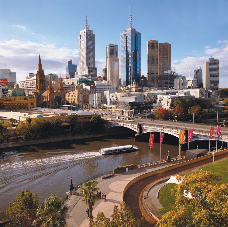 A riverboat plies the Yarra River beneath the Melbourne skyline near Federation Square as seen from Southbank.