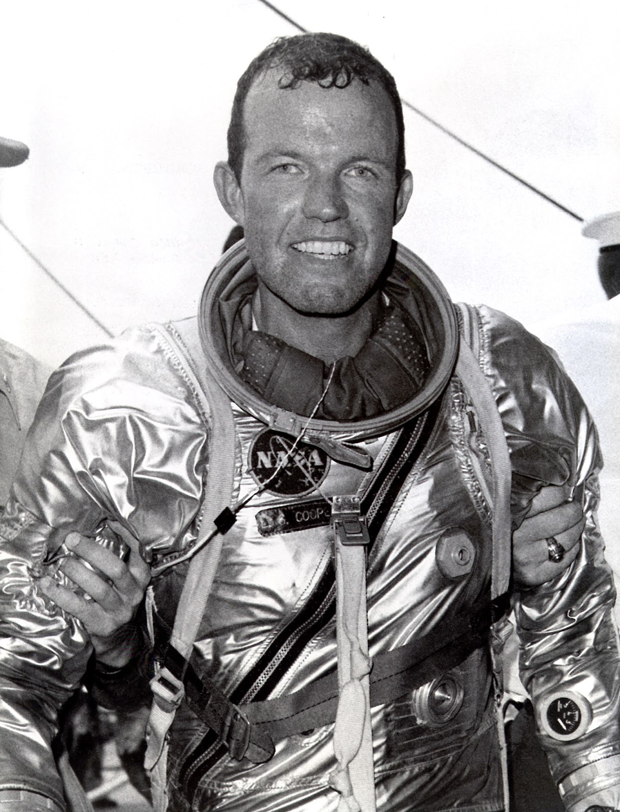 Gordon Cooper smiles in his spacesuit leaving the Faith 7 spacecraft.