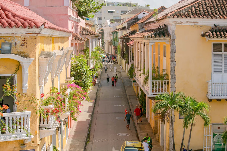 Visitors stroll a pretty street in Old Cartagena, Colombia. 