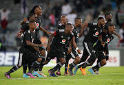 Orlando Pirates players run to congratulate Richard Ofori after the goalkeeper scored the winning spot kick during a penalty shoot-out. 