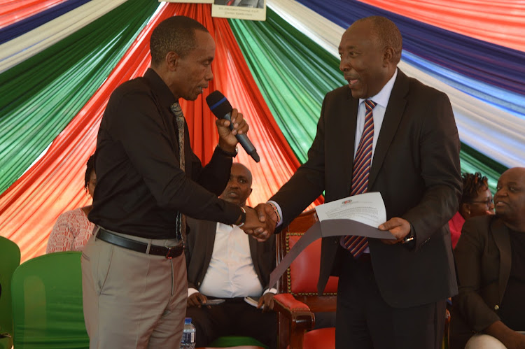 Governor Kimani Wamatangi (left) hands an appointment letter to T. G Ndorongo from the Association of urban areas and cities to an ad hoc committee meant to ensure Thika is elevated into an Industrial smart city