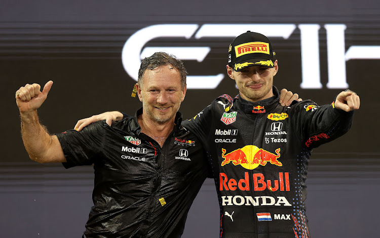 Race winner and 2021 F1 World Drivers Champion Max Verstappen celebrates with Red Bull Racing Team Principal Christian Horner on the podium during the F1 Grand Prix of Abu Dhabi at Yas Marina Circuit on December 12, 2021 in Abu Dhabi, United Arab Emirates.