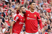 Bruno Fernandes of Manchester United celebrates with Cristiano Ronaldo after scoring their side's third goal during the Premier League match between Manchester United and Newcastle United at Old Trafford on September 11, 2021 in Manchester, England. 