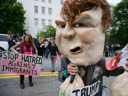 A masked protester demonstrates outside Republican National Committee (RNC) headquarters, where Republican US presidential candidate Donald Trump was meeting with House Speaker Paul Ryan (R-WI) and RNC Chairman Reince Priebus in Washington, US, May 12, 2016. Photo/REUTERS