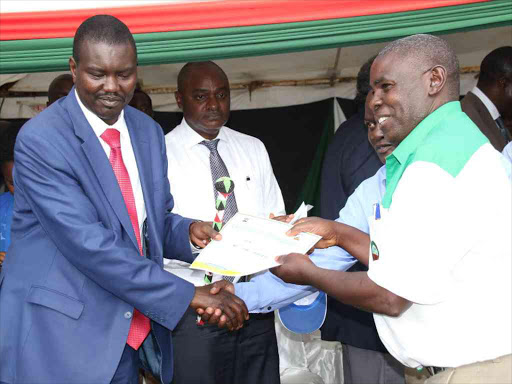 Uasin Gishu Governor Jackson Mandago hands certificates at a farmers' meeting in Eldoret, December 18, 2017. /MATHEWS NDANYI