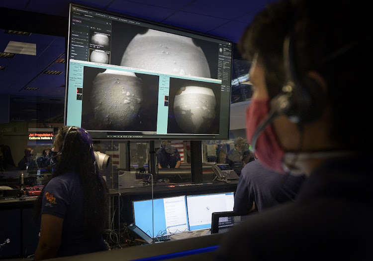 Members of Nasa’s Perseverance Mars rover team watch in mission control at Nasa's Jet Propulsion Laboratory in southern California as the first images arrive moments after the spacecraft successfully touched down on Mars.