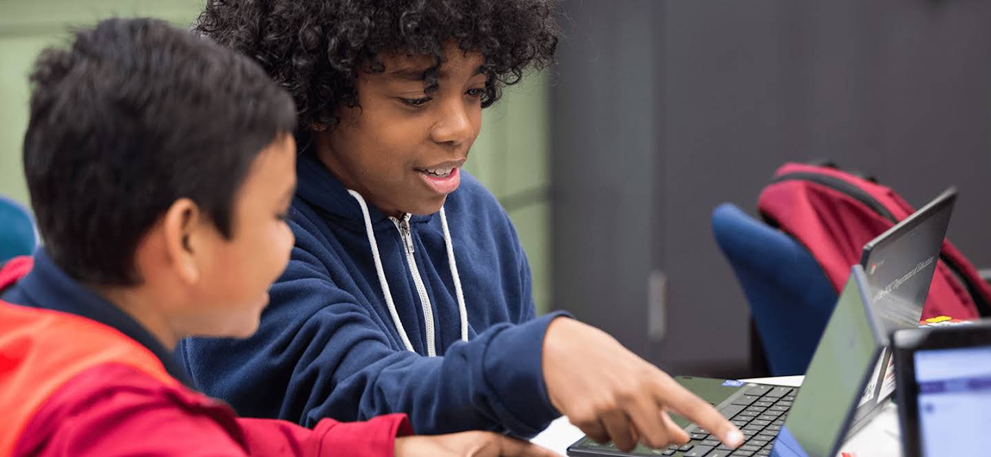 Two students using chromebooks in the classroom.