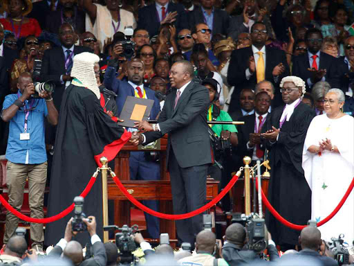 President Uhuru Kenyatta shakes hands with Chief Justice David Maraga as he takes the oath of office during his swearing-in at Kasarani stadium in Nairobi, November 28, 2017. /REUTERS