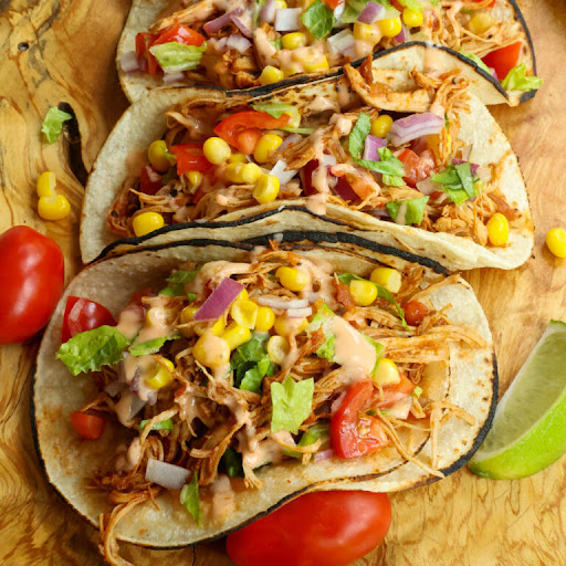 Tasty and tender Crock Pot Chicken Tacos made easy in the slow cooker.  Customize with all your favorite toppings and drizzle with chipotle ranch.

