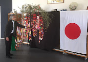 Shuichiro Kawaguchi, deputy head of mission of the Japanese embassy, explains the significance of the decorated bamboo plant at Sascoc on Thursday. 