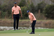 Charlie Woods plays a shot on the ninth hole as Tiger Woods looks on during the first round of the PNC Championship at the Ritz Carlton Golf Club Grande Lakes on December 18, 2021 in Orlando, Florida. 