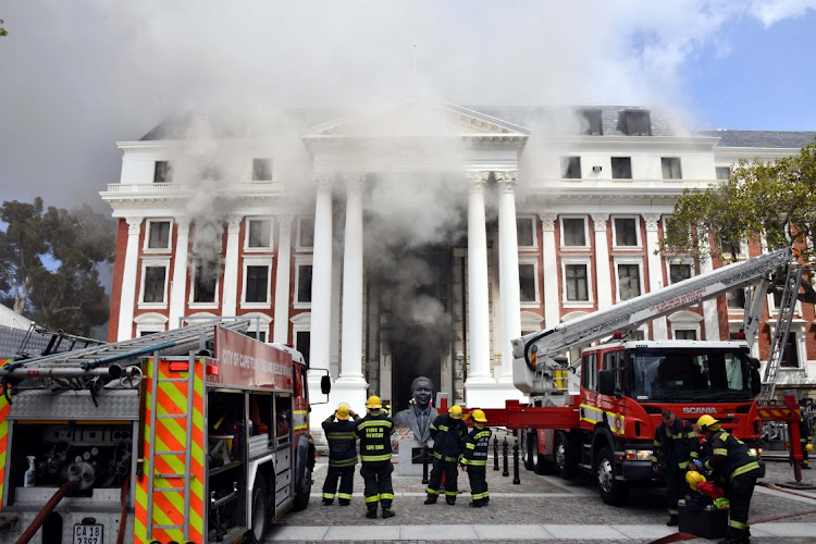 Firemen at work in parliament where a fire broke out in Cape Town on Sunday.