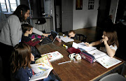 Marina Brebion, a school teacher in Nantes, France, helps her children with schoolwork during a lockdown to prevent the spread of the coronavirus outbreak.