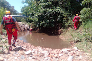 Emergency rescue members search the Jukskei River. 