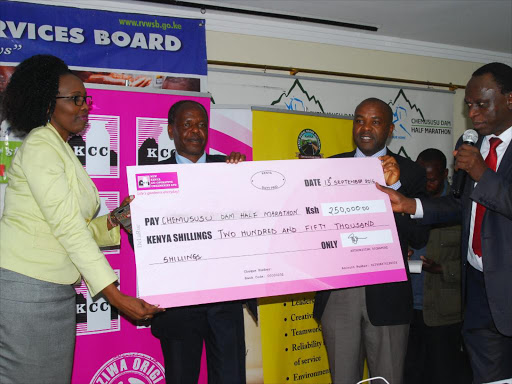 New KCC’s Stacy Too (L) hands a cheque to Machakos Town MP Victor Munyaka (R) as Chemusus race chair Josphat Kigen (2nd L) and Eldama Ravine MP Moses Lesonet look on.