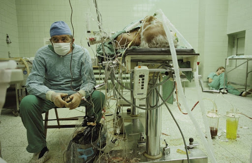 GS Zbigniew Religa - người tiên phong trong lĩnh vực phẫu thuật cấy ghép tim tại Ba Lan - ngồi trầm ngâm sau ca phẫu thuật thành công kéo dài 23 giờ. Trong khi đó, trợ lý của ông ngủ gục ở góc phòng vì kiệt sức.