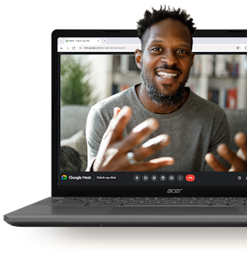 Homme en train de sourire pendant un appel Google Meet qui s'affiche sur l'écran d'un Chromebook ouvert.