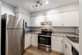 Modern kitchen with stainless steel appliances, white cabinetry, and a clean, spacious design. 