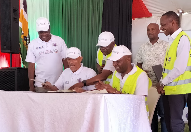 EACC CEO Twalib Mbarak with Murang’a Governor Irungu Kang’ata sign the Corruption Risk Assessment action plan on Saturday during celebrations to mark International Anti-Corruption Day