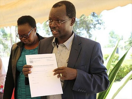 West Pokot Governor John Lonyangapuo hands out bursary cheques at Makutano on May 3.