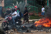 Demonstrators past a barricade as they take part during a protest over a controversial reform to the pension plans of the Nicaraguan Social Security Institute (INSS) in Managua, Nicaragua on April 21, 2018. 