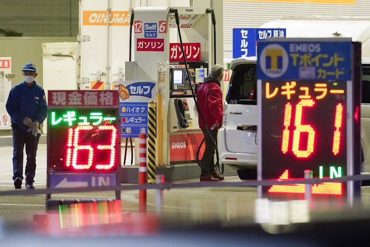 A customer refuels a vehicle at an Eneos gas station, operated by JXTG Nippon Oil & Energy Corporation in Tokyo, Japan on Friday, November 19 2021. Picture: BLOOMBERG/TORU HANAI