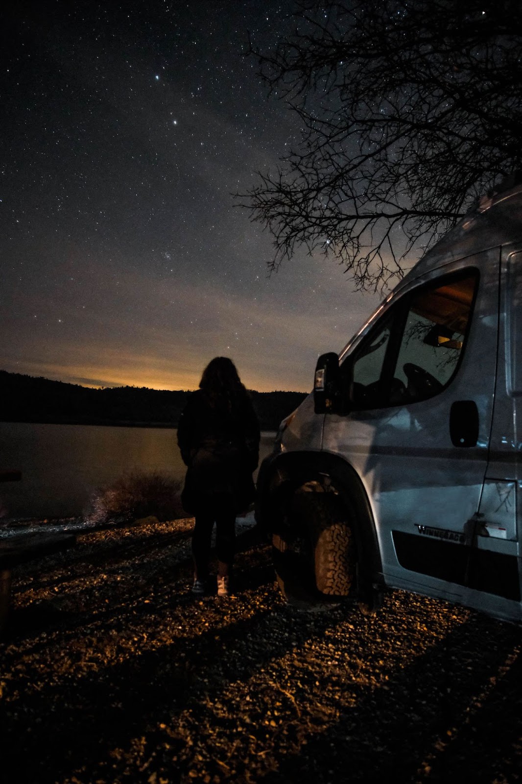 Outdoorsy Campervan rental under star filled sky by lake