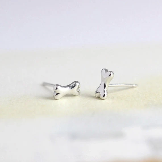 Brincos de Studs Osso da Sorte Little Wish. Pequenos e charmosos, trazem um toque de sorte e estilo ao seu visual diário, perfeitos para qualquer ocasião.