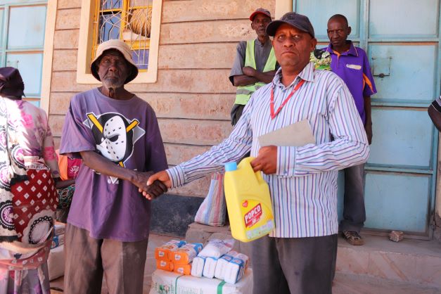 An elder receives food from Ambrose Safari.