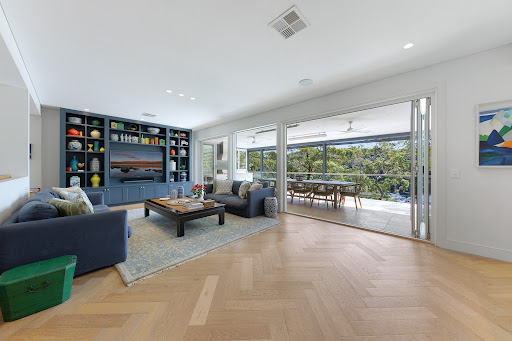 Living room with blue bookshelf and terrace in this luxury house for sale in Sydney