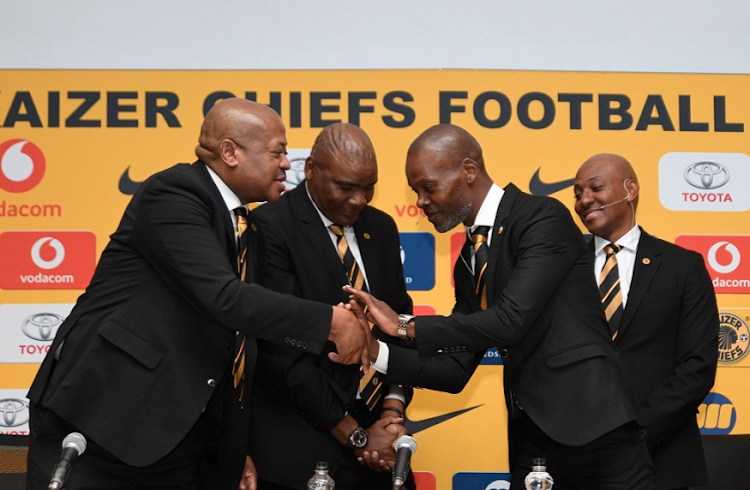 Kaizer Chiefs' football manager Bobby Motaung, left, congratulates Arthur Zwane on his appointment as head coach while head of technical Molefi Ntseki, second left, and sporting director Kaizer Motaung Junior look on at the press conference to announce Zwane's appointment.