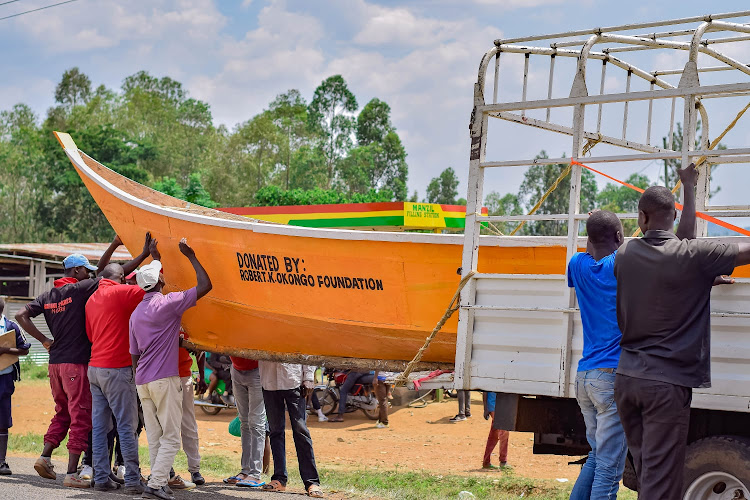 Curios onlookers mill around the 'Floating' boatd which has been on a campaign trail for governor aspirant Robert Okong'o