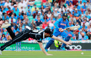 India's Ravindra Jadeja watches as New Zealand's James Neesham attempts to catch the ball.