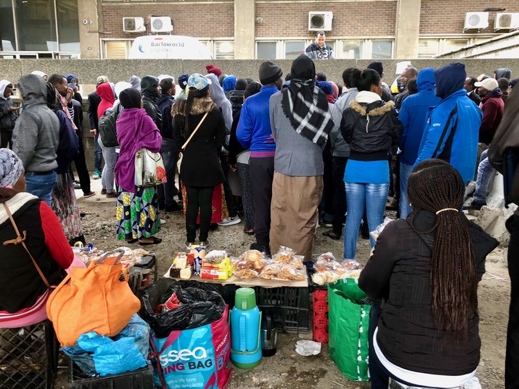 A Home Affairs official calls out people’s names outside the Foreshore offices.