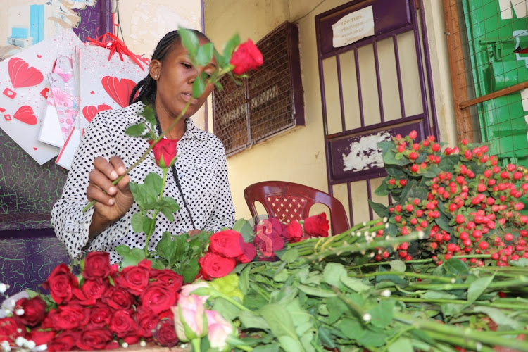 Sandra Mwatabu arranging bouquet of red roses outside her shop at Voi, Taita Taveta County on Valentine's day, February 14, 2023.