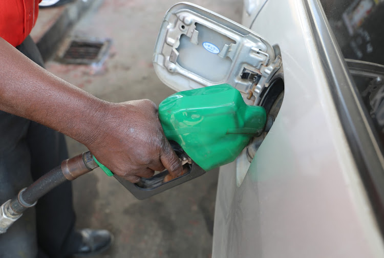 An attendant fuels a car at a pump station/ John Chesoli