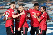 Manchester United's Bruno Fernandes celebrates with teammates after scoring a goal.