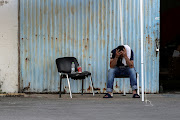 A migrant who was rescued at open sea off Greece along with other migrants, after their boat capsized, reacts outside a warehouse used as a shelter, at the port of Kalamata, Greece, on June 15 2023.