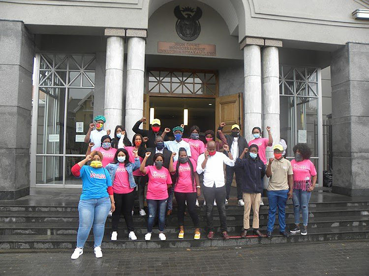 Some of the workers who were suspended by Truda Foods in Queenstown stand at the entrance to the Port Elizabeth High Court where the Labour Court sat on Thursday.