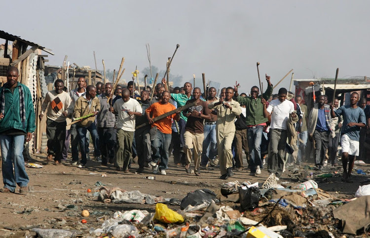 A mob prepares to attack in Johannesburg's Ramapahosa squatter camp as xenophobic attacks escalate in 2008.