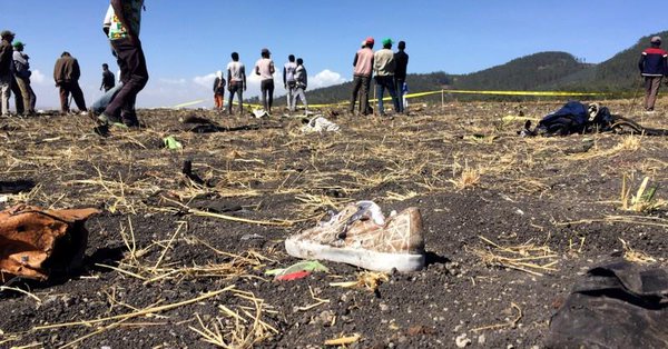 People walk at the scene of the Ethiopian Airlines Flight ET 302 plane crash.