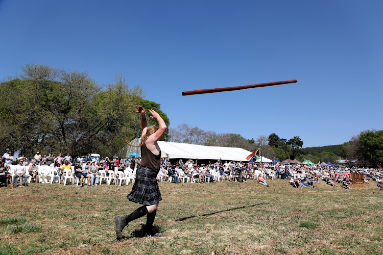 A man participates in the 'Tossing the Caber' challenge where contestants have to hold and then to throw and turn in its full length, a pole longer than the average minibus.