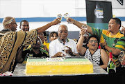 President Jacob Zuma, a teetotaller, struggled with the ANC's lukewarm birthday bubbly in Khayelitsha yesterday. He is flanked by party bigwigs including deputy secretary-general Jessie Duarte, Deputy Minister of Telecommunications Hlengiwe Mkhize, MP Mandla Mandela, chaplain-general Vukile Mehana and Western Cape chairman Marius Fransman