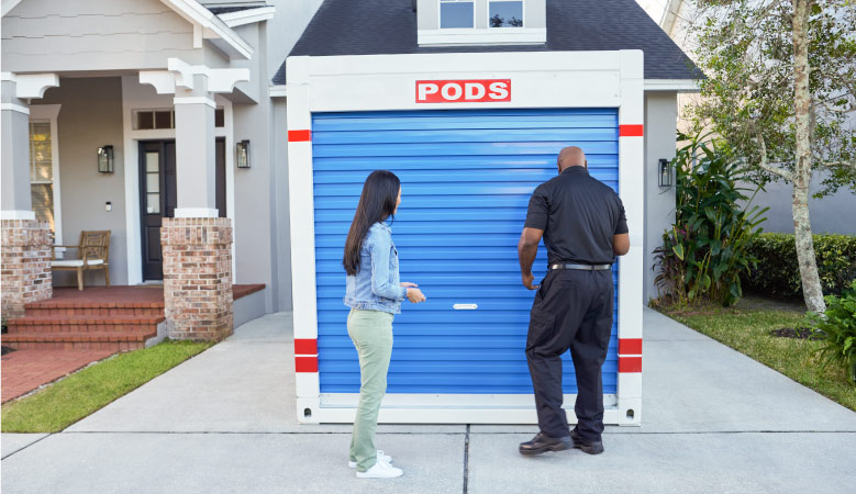 A PODS driver shows a homeowner her PODS portable storage container. She’s keeping it in her driveway to use as on-site storage while she does a large redecorating project in her home.