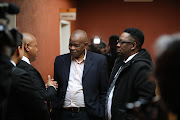 Zolile Sekeleni, middle, father of Dr Nandipha Magudumana, talks to lawyers in the Bloemfontein magistrate's court. 