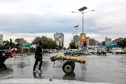 A vendor pushes his cart across a street in Harare. Zimbabweans are bracing for a bleak festive season after the government effectively banned Christmas parties due to Covid-19. File photo.