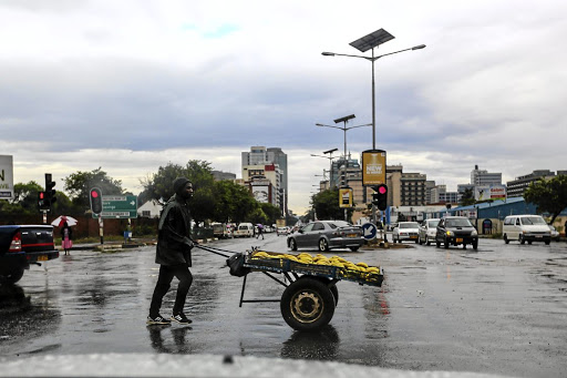 A vendor pushes his cart across a street in Harare. Zimbabweans are bracing for a bleak festive season after the government effectively banned Christmas parties due to Covid-19. File photo.