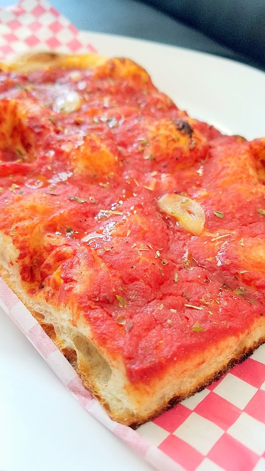 Roman Candle Baking Company offers a Roman style Pizza Bianca- here is Pomodoro with Tomato, oregano, xvoo, sea salt